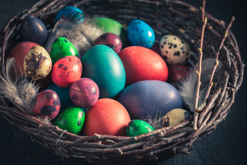 Various eggs for Easter in old wicker basket