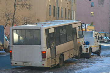 evacuation of a broken bus by a tow truck along a city street