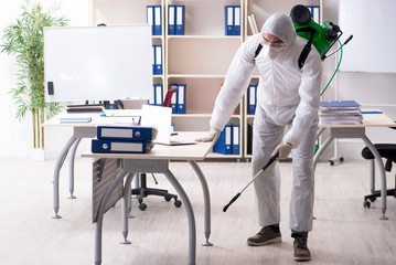 Professional contractor doing pest control at office 