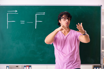 Young male physic standing in front of the green board