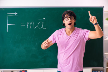 Young male physic standing in front of the green board