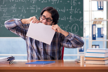 Young funny math teacher in front of chalkboard 