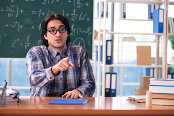 Young funny math teacher in front of chalkboard 