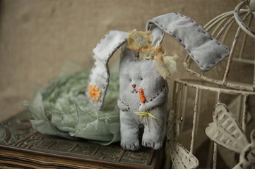 Handmade Bunny Rabbit. Gray textile rabbit with a carrot. Easter decor for the interior. Toy hare fabric. 