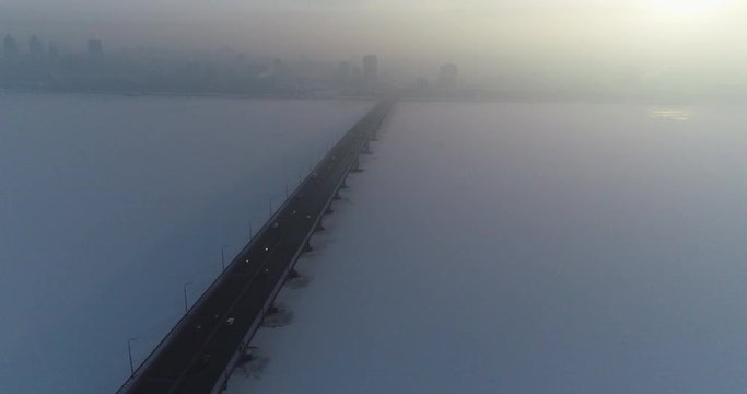 (original 4k file)  Static shooting from the drone of a road bridge in the fog with cars moving along it