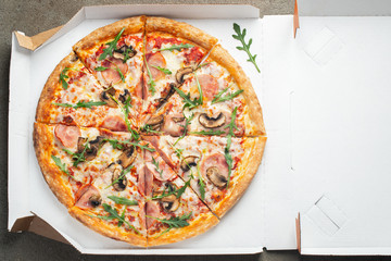 Delicious hot pizza in a box with ham.