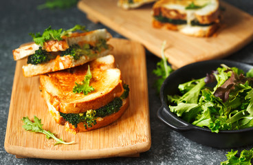 Broccoli and cheddar cheese sandwiches on wooden cutting boards.