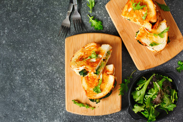 Broccoli and cheddar cheese sandwiches on wooden cutting boards, top view.