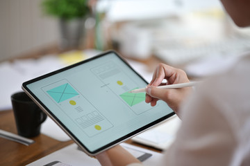 Designer using tablet planning wireframe a mobile website, UX UI app development