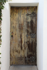 A modern home entryway is shown with a door made from old, reclaimed / recycled lumber.