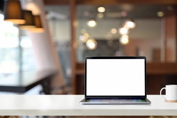 Mockup blank screen laptop on white desk table in office