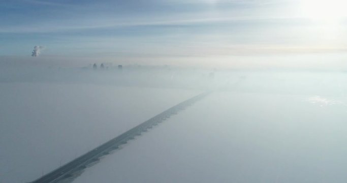 (original 4k file) Bridge with running cars on it in the winter morning fog