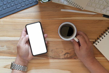 Male hands using smartphone blank screen mockup at the office desk