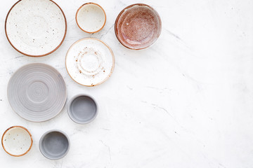 Ceramic tableware pattern. Empty plates and mugs on white background top view copy space