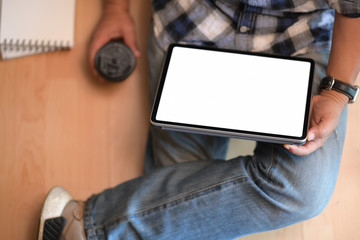 Young man sitting on floor with working on tablet
