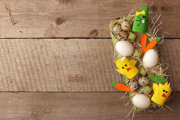 Easter rabbits and eggs decoration in interior on a vintage wooden background, springtime concept, flat lay, top view © misskaterina