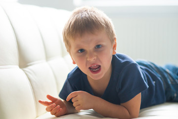 Portrait of hysterical boy. Upset caucasian kid crying at home.