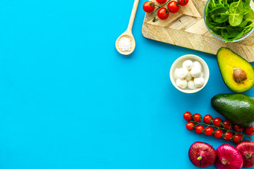 Fresh organic vegetables on blue background top view copy space. Kitchen desk for preparing salad
