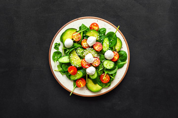 Healthy lunch. Fresh vegetable salad on black background top view space for text