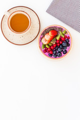 Healthy vegetarian breakfast. Acai smoothie bowl with fresh fruits, berries, chia seeds on white background top view space for text