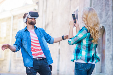 Couple walking in the street in augmented reality headset. Virtual reality and futuristic technology concept.