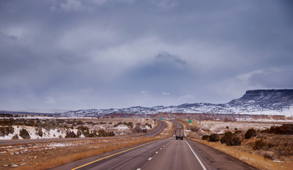 The lone road through the off old Route 66 desert landscape white as snow.