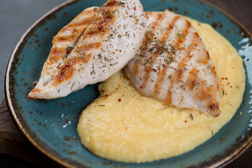 Close-up of polenta with fried chicken breast fillet, selective focus