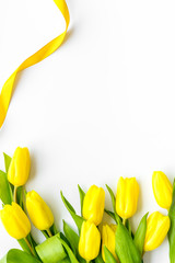 Spring composition. Delicate yellow tulips on white background top view copy space border