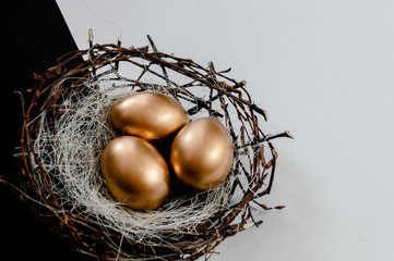 Golden Easter Eggs in birds Nest on black and white abstract background. Easter Holiday concept ...