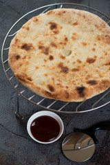 Metal cooling rack with freshly baked ossetian pie, vertical shot, close-up
