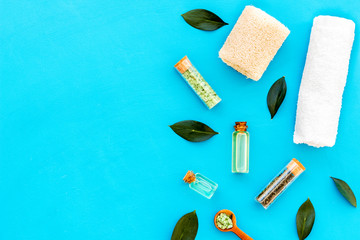 Tea tree spa composition. Fresh tea tree leaves, natural cosmetics, towel on blue background top view space for text border