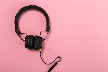 black headphones on pastel background.