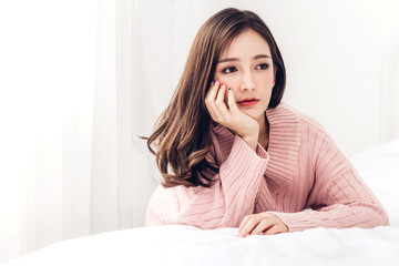 Portrait of happy smile asia woman enjoy and relax on the bed in bedroom at home.asian beauty