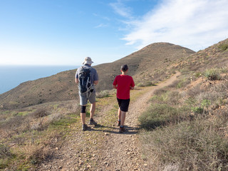 Fototapeta na wymiar Father and son walking, Chumash and Mugu Peak trail, Point Mugu State Park, Ventura County, California, USA