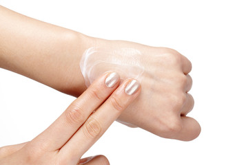 Woman applies cream on her hands isolated on white background.