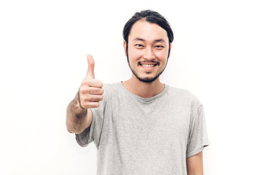 Portrait of happy smiling asian young handsome man with thumb up on white background