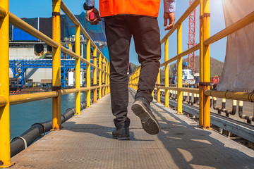 Safety shoe of worker or engineering walking in mind step on the steel checker plate, gangway bridge in safety walkway at workplace, working in high stage and high level of insurance