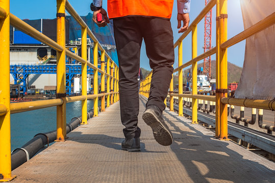 Safety shoe of worker or engineering walking in mind step on the steel checker plate, gangway bridge in safety walkway at workplace, working in high stage and high level of insurance