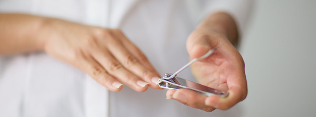 close up shot of a woman cutting her nails for banner background, selective focus