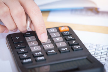 Businesswoman working in the office with calculator for financial data analyzing counting. Business financial analysis and strategy concept.