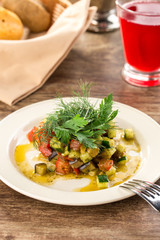 Grilled vegetables warm salad with zucchini, eggplant, onions, peppers and tomato with berry juice on wooden table