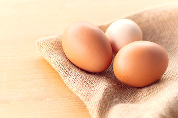 raw egg on burlap on wooden table