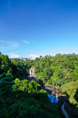 Tegenungan waterfall from hill with blue skies above Kemenuh Village, Sukawati, Gianyar, Bali, Indonesia