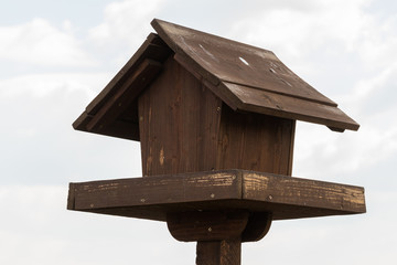 A Small Wooden Bird House Facing the Grey Clouds