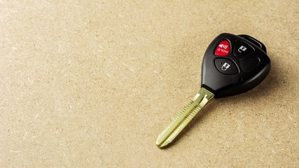 Modern electronic car keys on wooden desk.