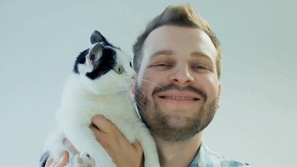 happy smiling bearded man with black and white domestic cat, human emotion