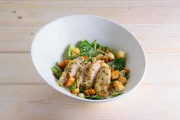 Spinach salad with boiled chicken breast, croutons sprinkled with rubbed Parmesan cheese