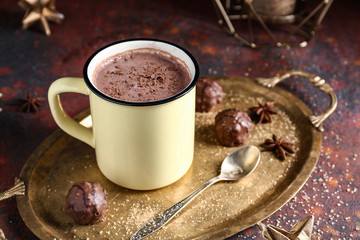 Cup of hot cacao drink with candies on table