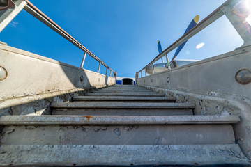 Old, worn passenger gangway. Gangway attached to the aircraft