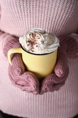 Woman holding cup of hot cacao drink, closeup